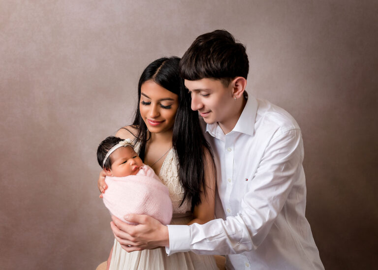 young couple holding a newborn baby girl